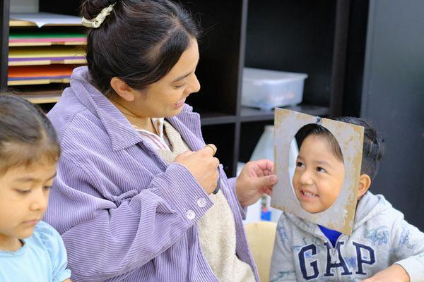 Preschool teacher during a classroom activity with student