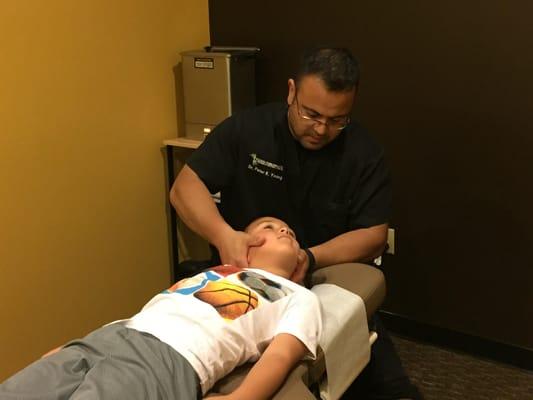 Dr. Young adjusting the neck of an 8 year old boy.