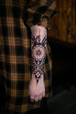 A gothic ornament on the top of the forearm. Very bold and dark motifs.