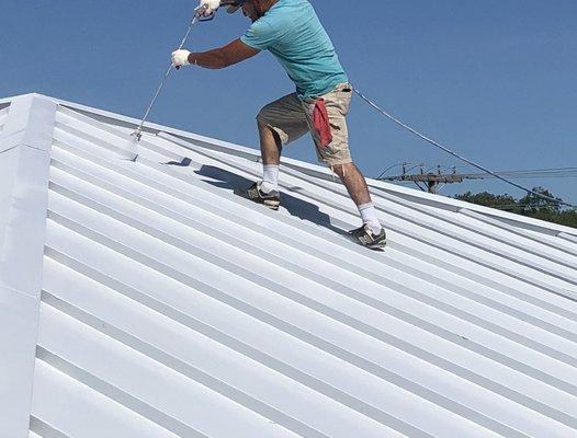 Applying a second coat on the roof coating.