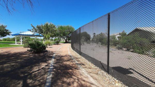 The Eastern edge of Duck Creek Park where a strip of desert between two fences buffer the neighboring houses.