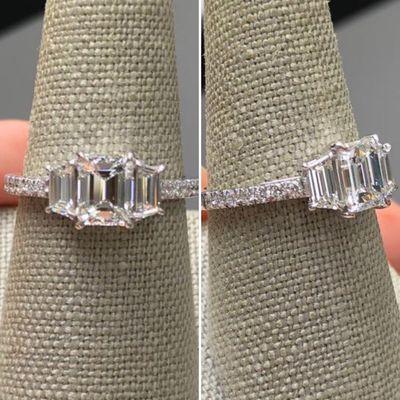 Custom designed center emerald cut diamond with trapezoid side diamonds and round brilliant band.