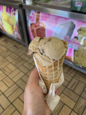 Coffee ice cream in a waffle cone.