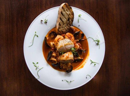 Cacciucco, Grilled NC shrimp, mussels, braised calamari, seared scallops ,roasted garlic,  red chili paste, tomato, crostini