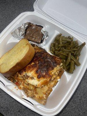 Homemade lasagna pair with green beans and garlic bread and a freshly baked brownie.