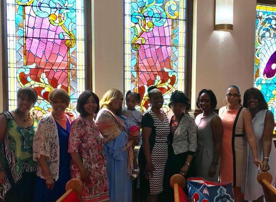 Family Love is in front of ZBC's stained glass church windows.