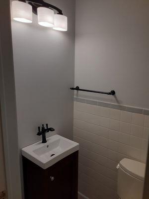 Powder room remodel. Included vanity, sink and faucet. New toilet, lighting, and flooring. Painting walls and ceiling to complete bathroom.