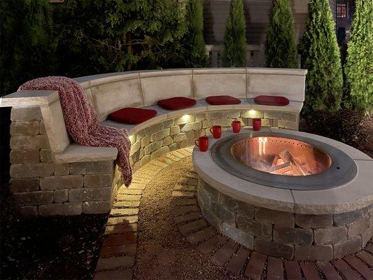 A luxurious Indiana limestone heated bench and smokeless fire pit create the perfect spot for cold evenings.