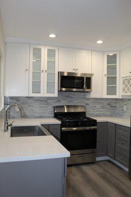 Remolded kitchen with all new cabinets, backlash, appliances, featured frosted glass cabinets, and flooring.