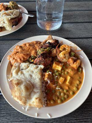 Naan, chicken tikka masala, tandoori chicken, spinach pakora, a paneer dish, and a shrimp dish