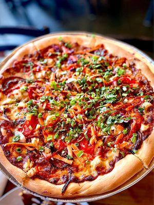 Thai Chicken Pizza, peanut sauce, chicken, red peppers, red onions, shredded carrots and cabbage, cilantro, scallions, and sriracha sauce