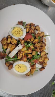 Arugula salad - arugula, onions, peppers, citrus dressing, topped with toston chips and hard boiled egg