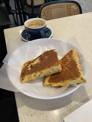 Egg, bacon, and cheddar piadinas with fancy sauce. And, a cup of Floridian coffee.