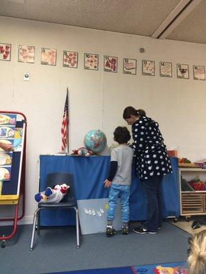 Pajama school day. One of the teachers supervising one of the kids feed the fish.