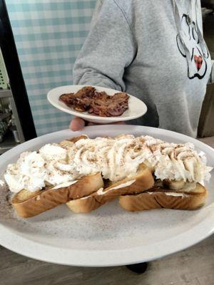 French toast with banana and whipped cream with a side of bacon