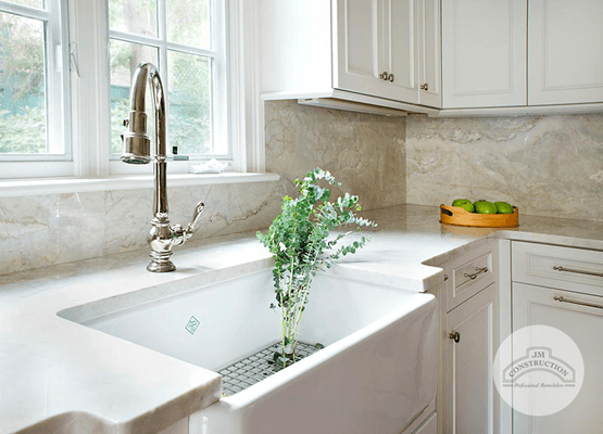 JM Construction added this striking porcelain sink to a bright, white kitchen.