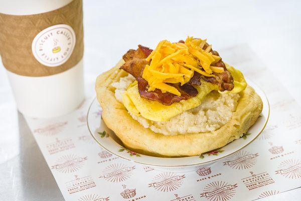 Callie's Hot Little Biscuit slow-cooker grits bowl topped with scrambled egg, crispy bacon, cheddar cheese. Hot coffee + breakfast!