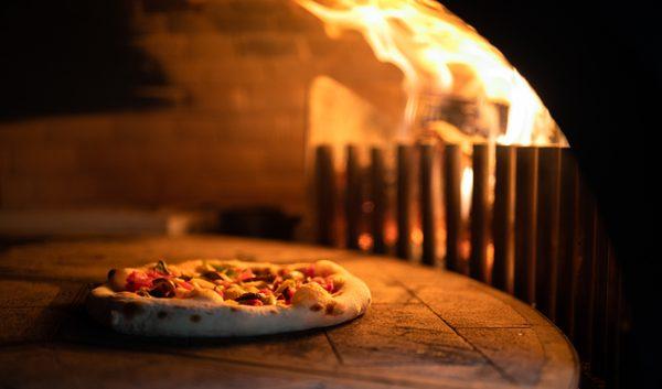 We cook our pizza in a wood-fired brick oven.