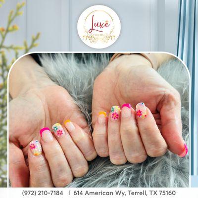 Spring whispers through your fingertips as blossoms adorn your nail design.