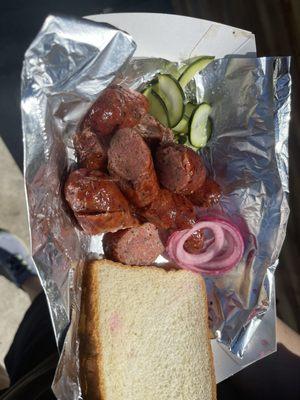 Sausage with red pickled onions and homemade pickles