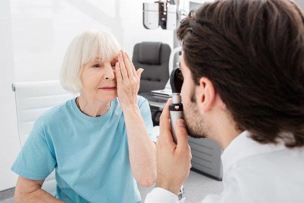 Senior woman covering her left eye during an eye exam