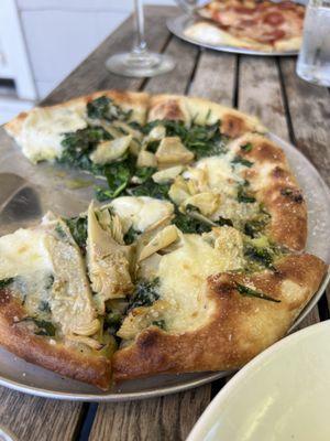 Almond and pesto pizza. With a pepperoni pizza in the background.