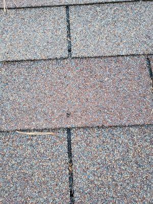 Improper nailing at an angle. Nail heads are creating breakage in my shingles.