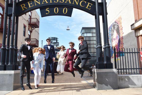 Excited jumping kids wearing prom suits and tuxedos