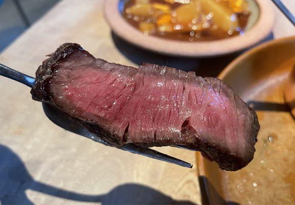 Velvety, perfectly medium-rare slice of dry-aged Wagyu ribeye. Sliced with surgical precision!