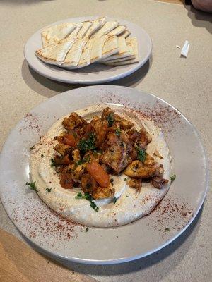 Hummus topped with chicken shawarma and served with pita triangles