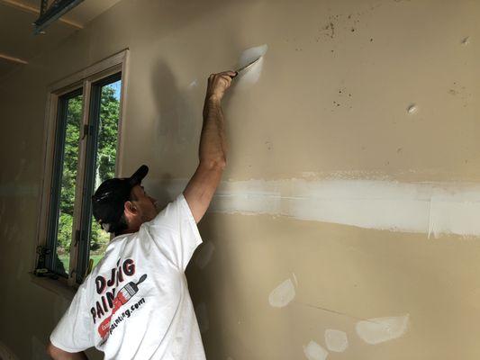 Expert painter spackling a wall to prep for painting