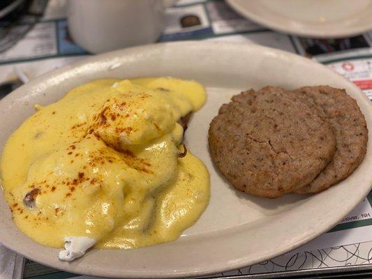 Eggs Benedict on gluten free toast with a side of sausage