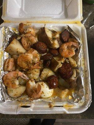 Shrimp platter with potatoes and sausages