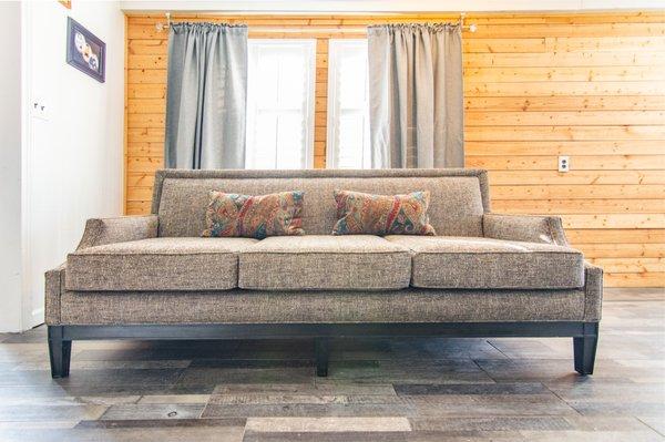 Custom sofa made from scratch with a solid wood base stained in a flat black color. Nail-heads around the squared back with 2 accent pillows