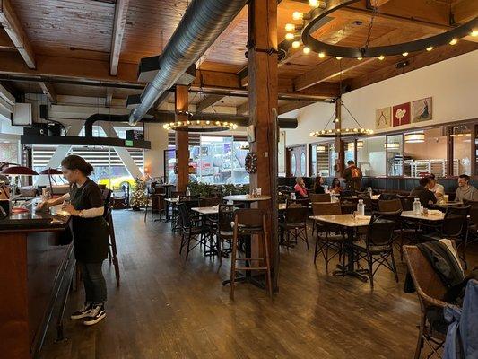 A view of the clean dining room with ample seating and a full bar.