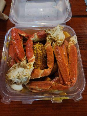 Crab legs, corn, potatoes, sausage, and boiled egg