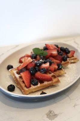 Our Waffle! Sliced into four pierces, strawberries and blueberries tossed in maple syrup and topped with powdered sugar. Delicious!