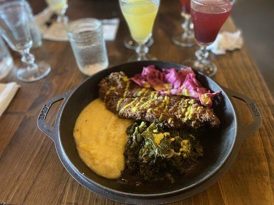 Catfish dinner, with grits, greens, and pickled cabbage.