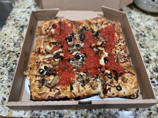 Detroit Pizza with Crumbled sausage, mushrooms and black olives.