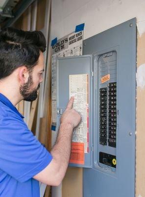 Our tech looking at the panel breaker to fix an electrical problem.