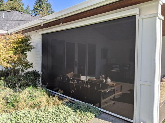 Retractable patio screen. Great for sun protection as well as rain and wind. You can see through fabric when rolled down