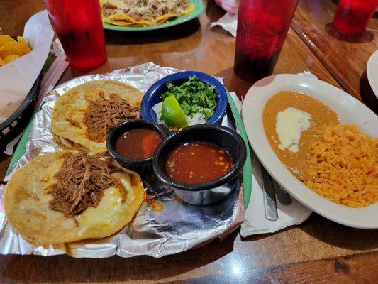 Quesabirria tacos with a side of rice and beans