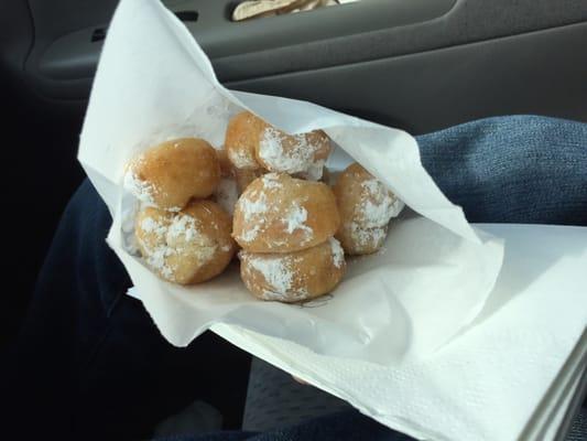 Bag of fresh mini donuts. Options are powdered sugar or cinnamon sugar.