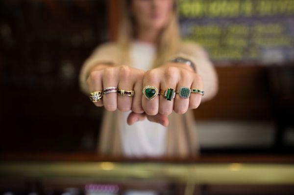 An array of emerald rings, tourmaline rings, and ruby rings.