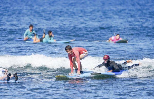 Raul helping my son catch a wave