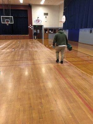 Pouring oil based finish on a wooded screen floor.