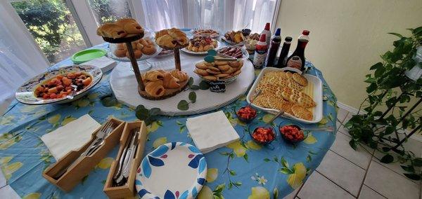 Ham and cheese croissants on the wood tiers. Cake doubts and holes on the cake plate. Donut holes and minicinnamon buns behind them.