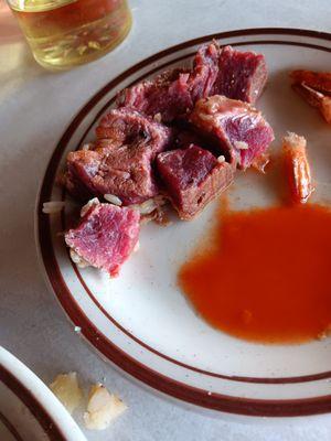 Raw beyond prime rib next to hot sauce