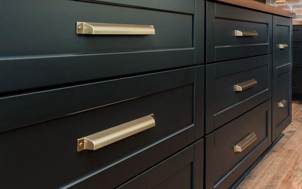 Increased storage with an island of pot and pan drawers. True Black finish with champagne gold pulls.