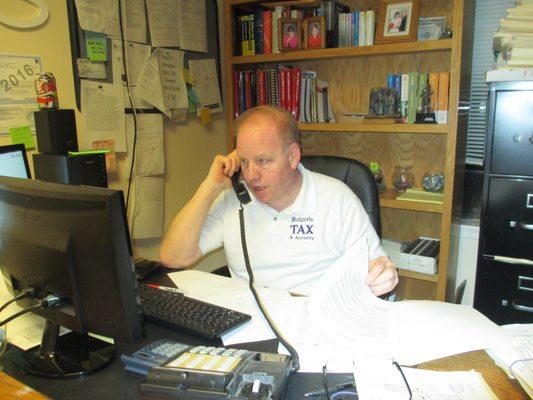 Peter in the front office, "chatting with the IRS!"  Note the can of Diet Coke always within easy reach.